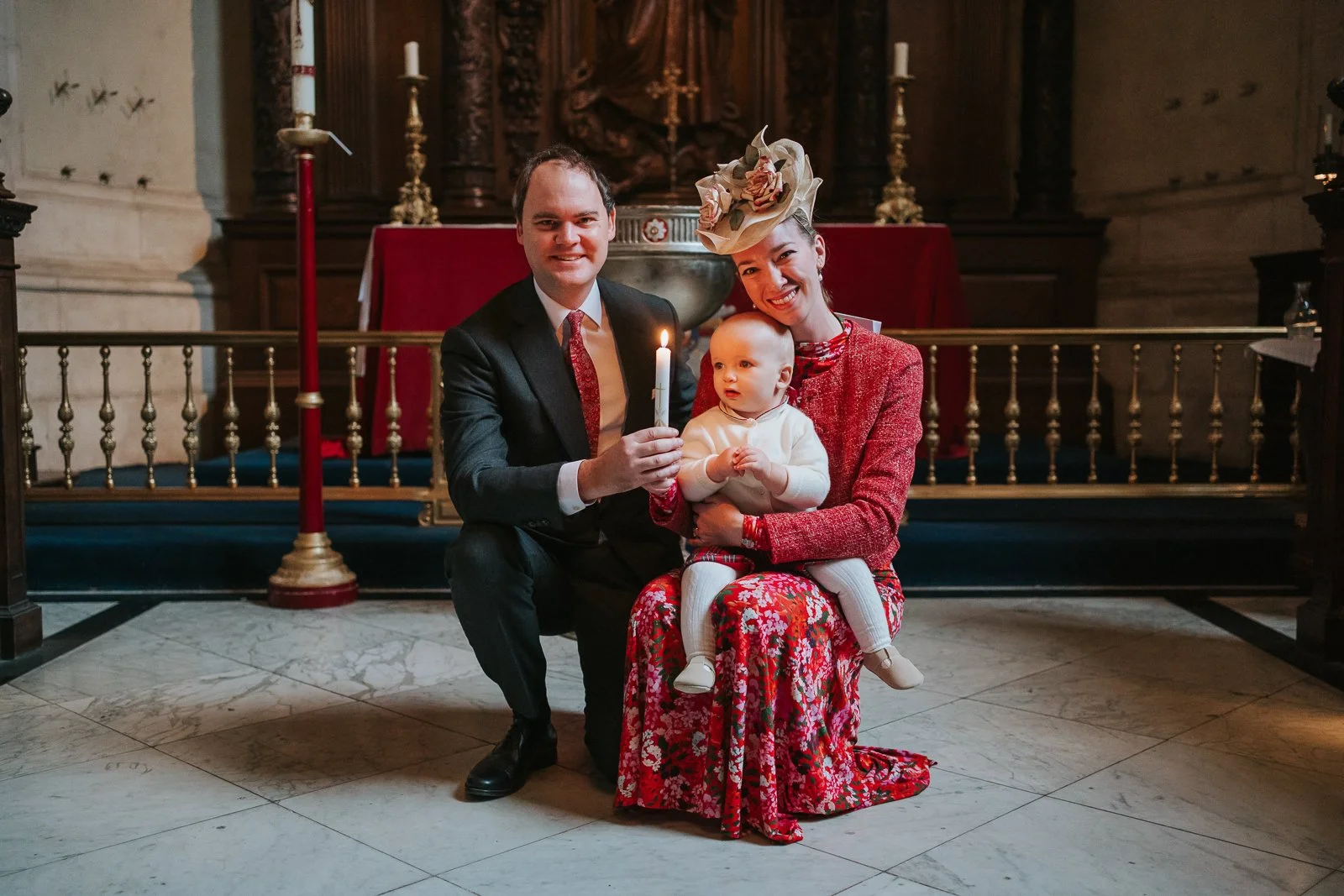  Parents and baby holding a christening candle inside the Chapel of the Order of St Michael and St George at St Paul’s Cathedral, photographed using available light 