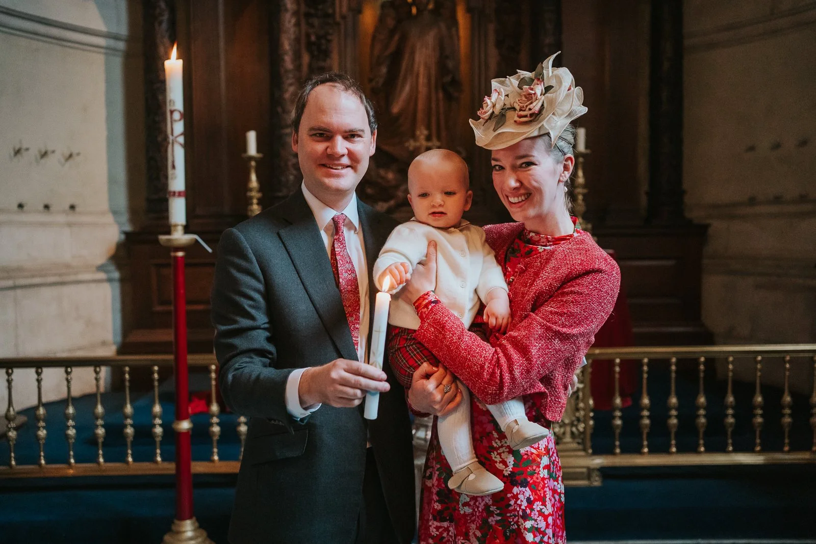  Parents holding their baby with a lit christening candle inside the Chapel of the Order of St Michael and St George, St Paul’s Cathedral 
