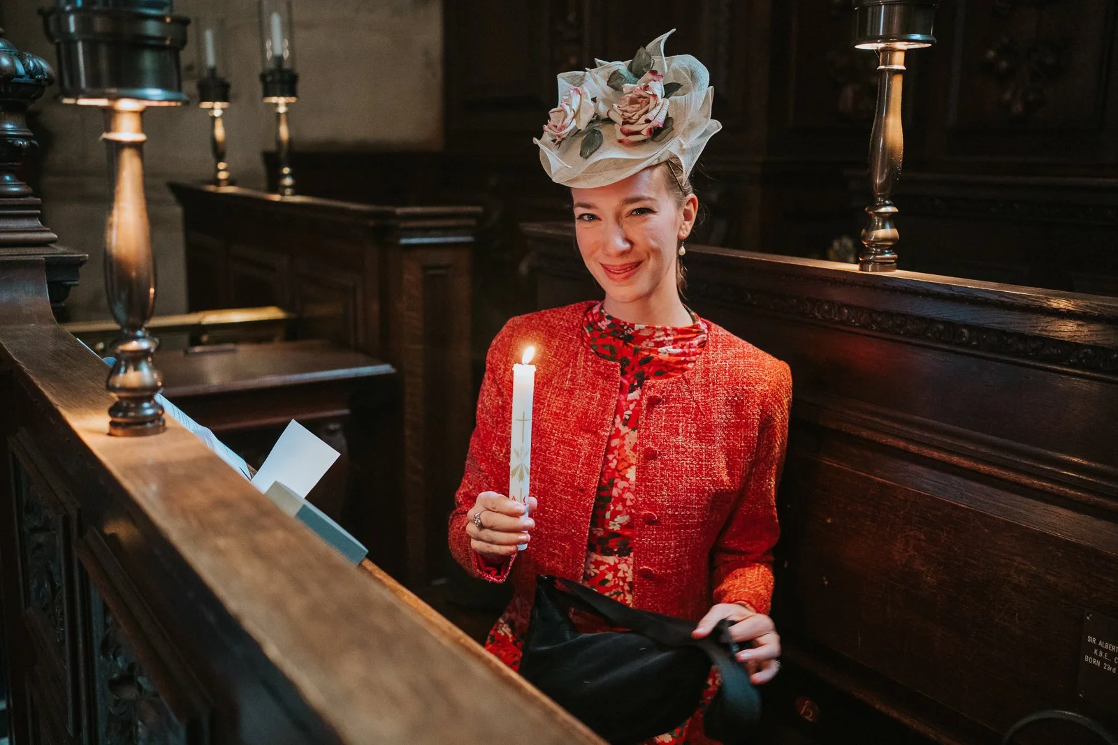  Mother holding a christening candle inside the Chapel of the Order of St Michael and St George, St Paul’s Cathedral, captured in low ambient light 
