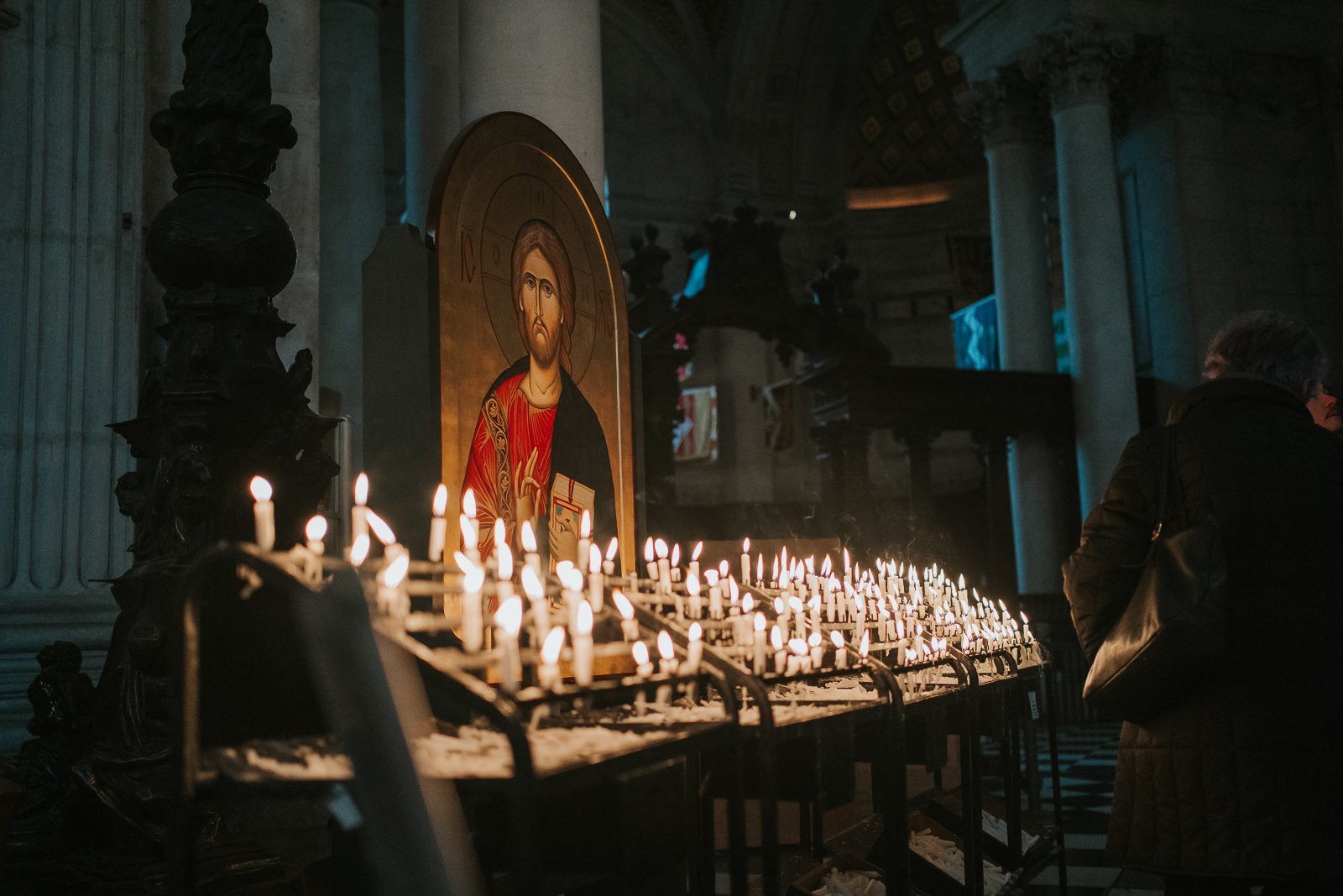  Rows of lit votive candles inside St Paul’s Cathedral, creating an atmospheric, candlelit interior scene 