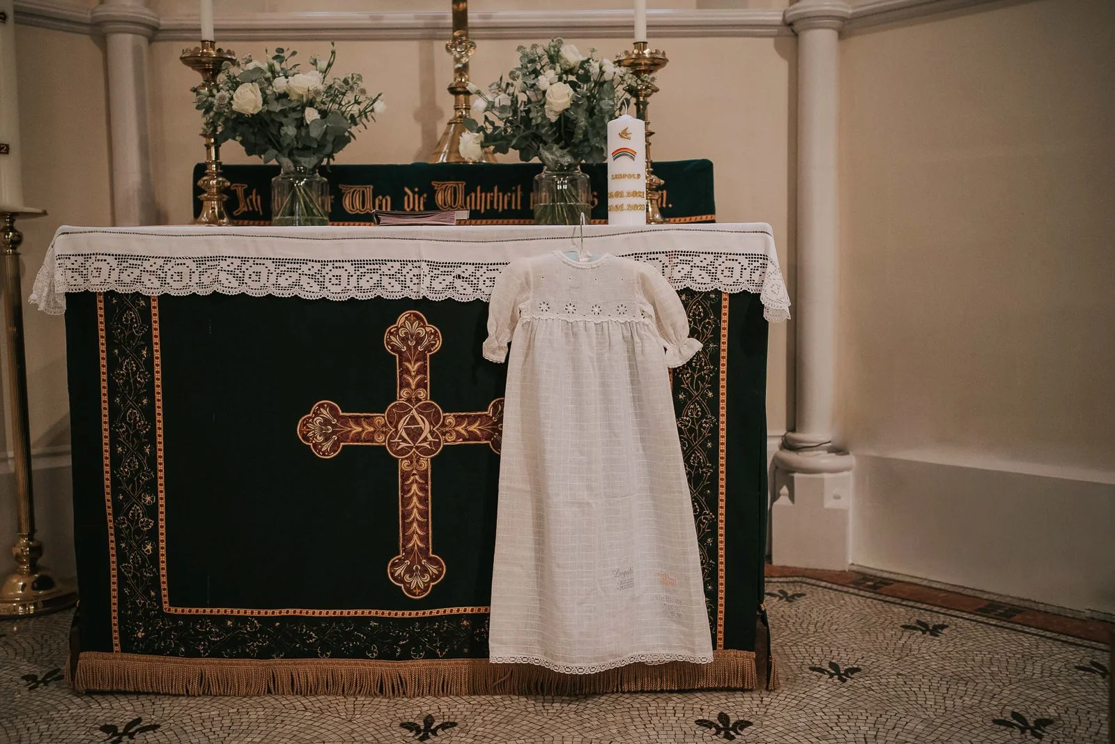  Baby christening gown displayed at church altar before Catholic baptism ceremony in London. 