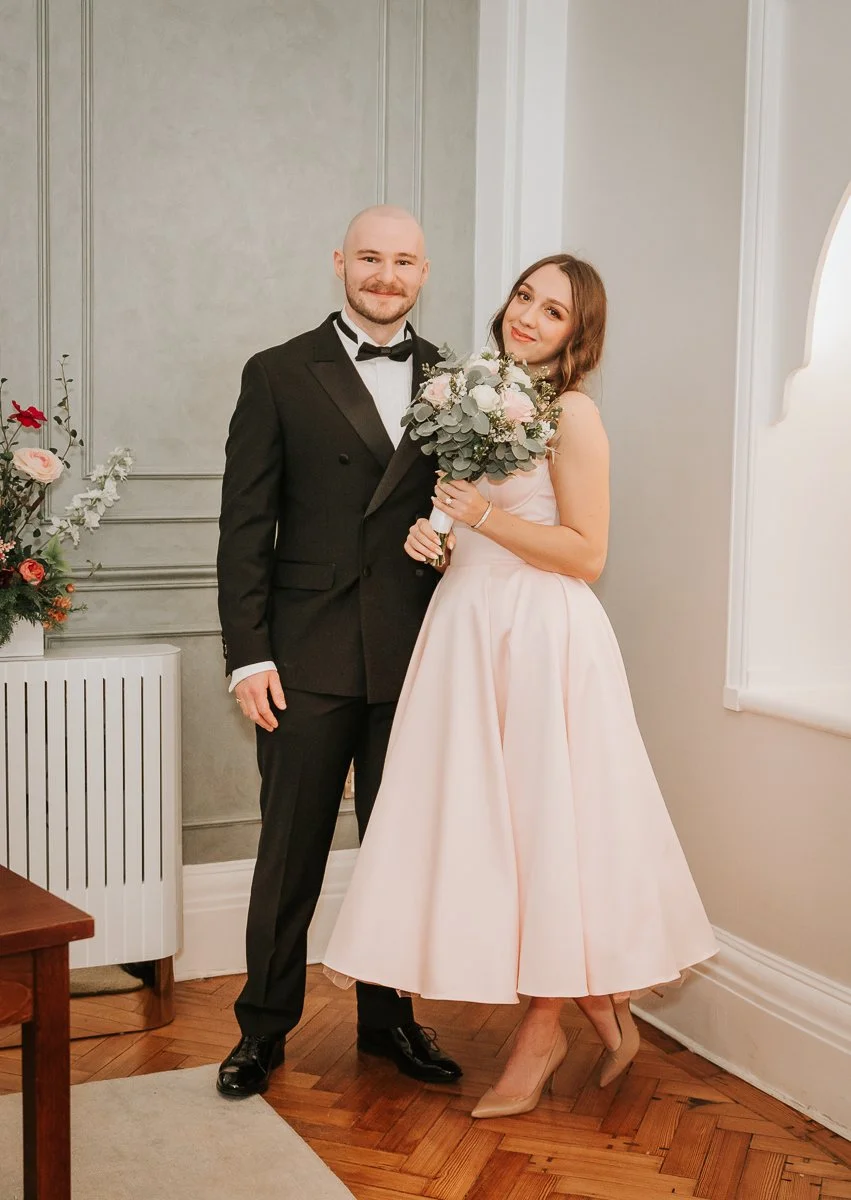  Bride and groom posing with bouquet in the Rossetti Room after their Chelsea Old Town Hall wedding ceremony. 