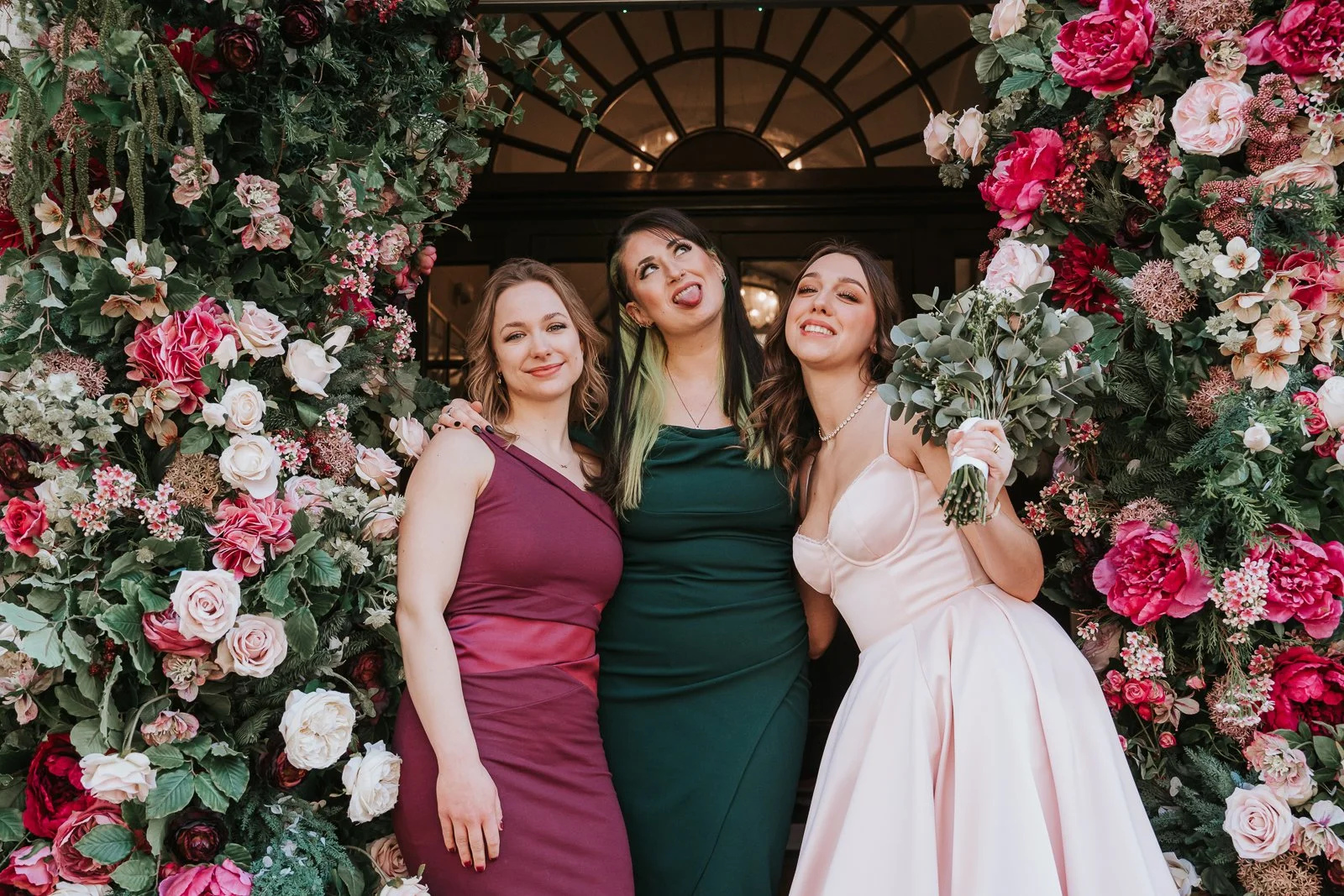  Bride celebrating with friends under the floral entrance after an intimate London civil ceremony 