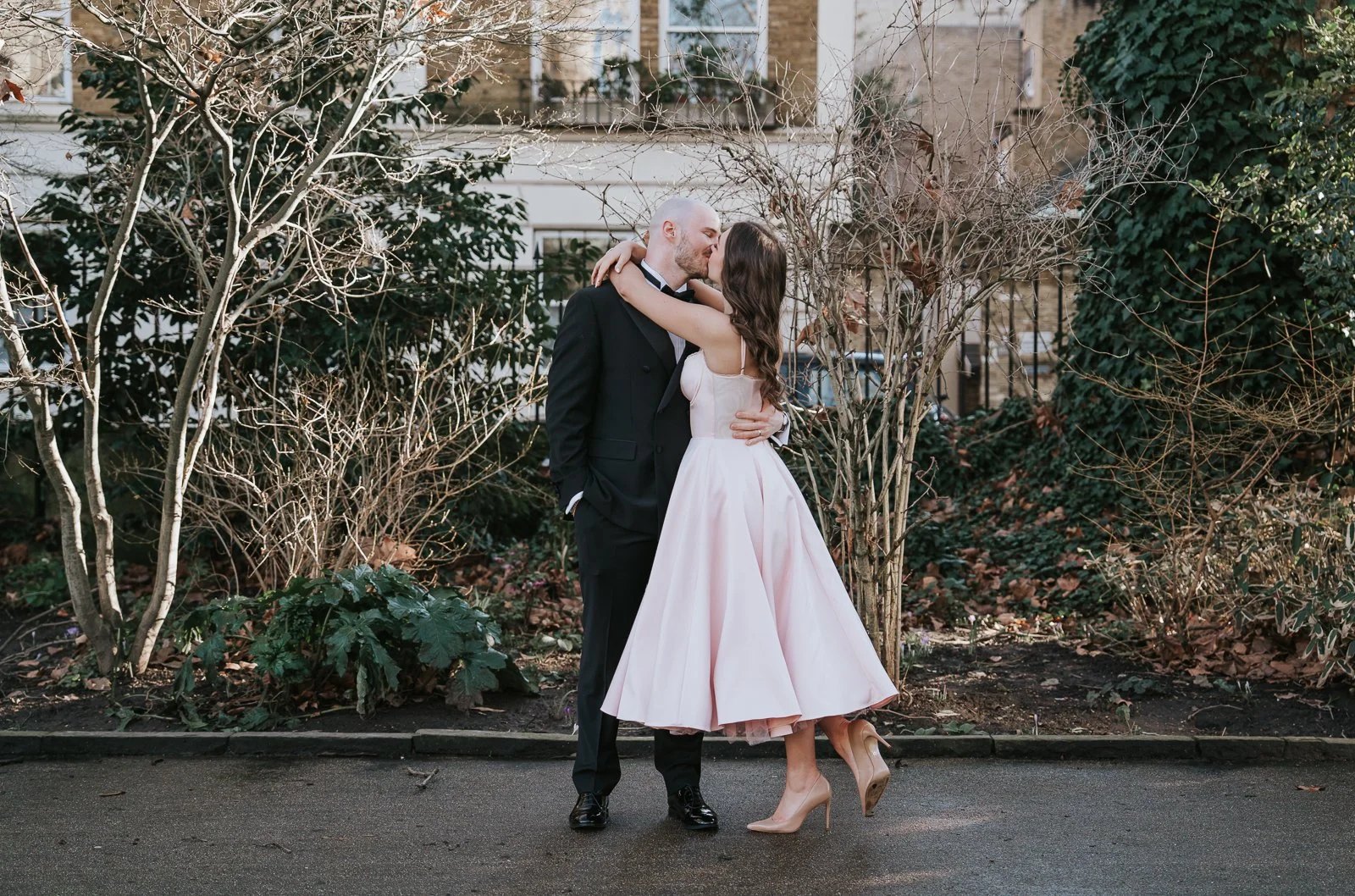  Newlyweds sharing a kiss during relaxed outdoor portraits following their intimate civil wedding celebration. 
