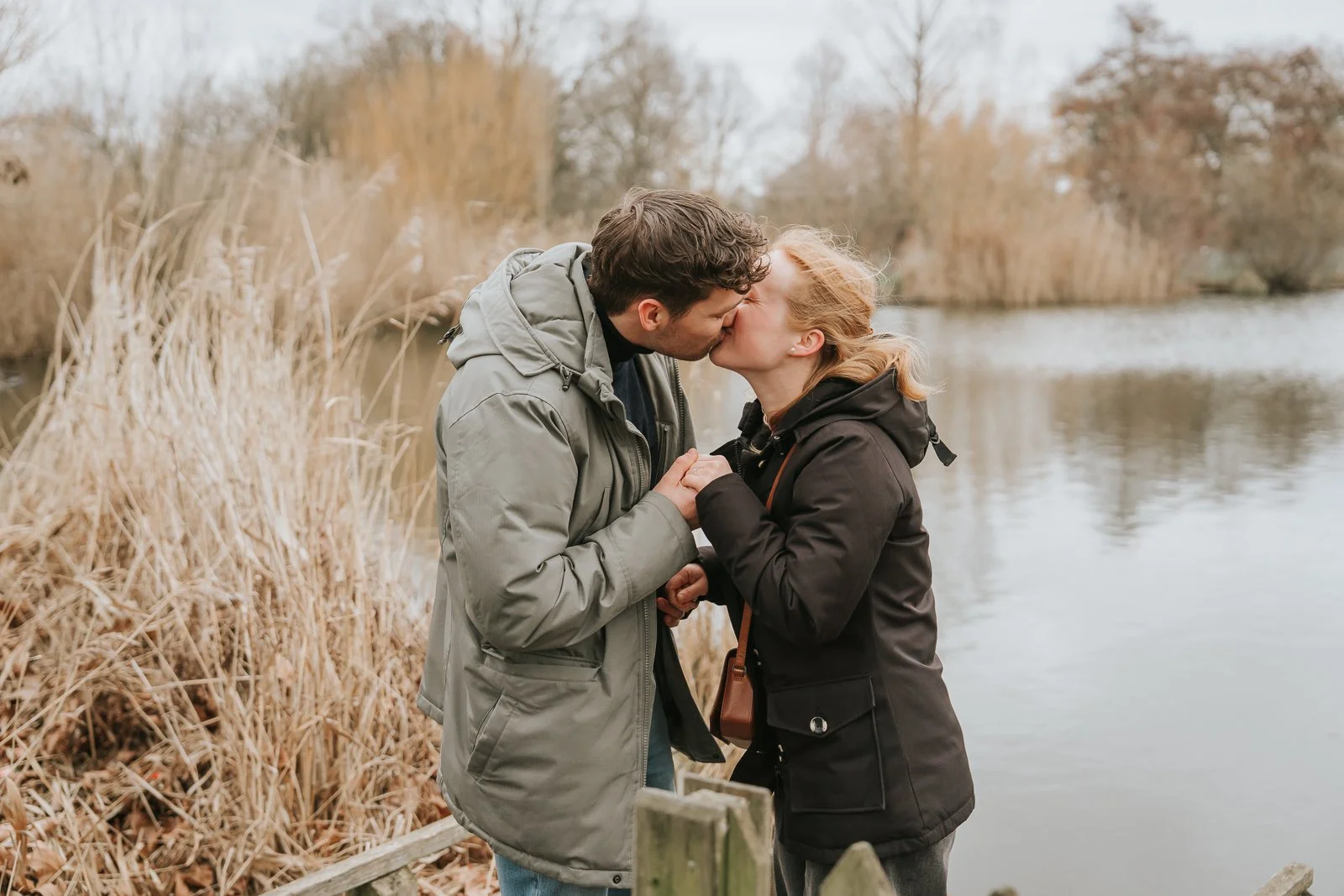  Romantic kiss on wooden jetty at Clapham Common following intimate proposal in South London. 