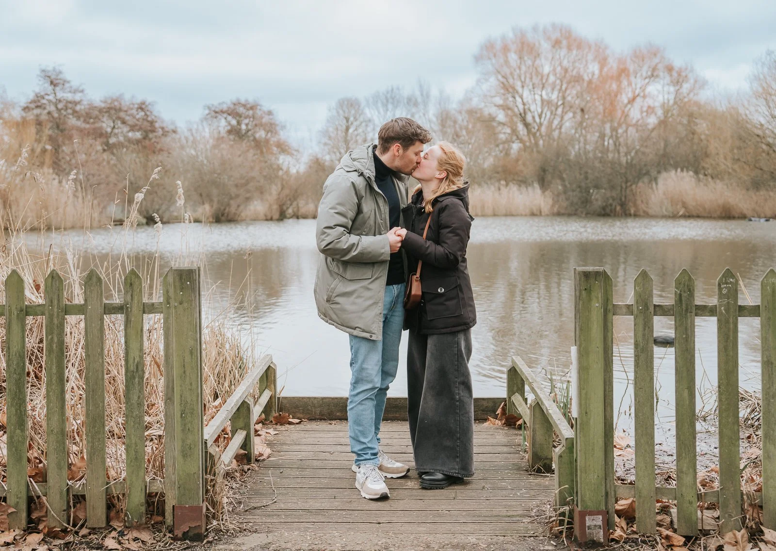   Romantic kiss on wooden jetty at Clapham Common following intimate proposal in South London.   