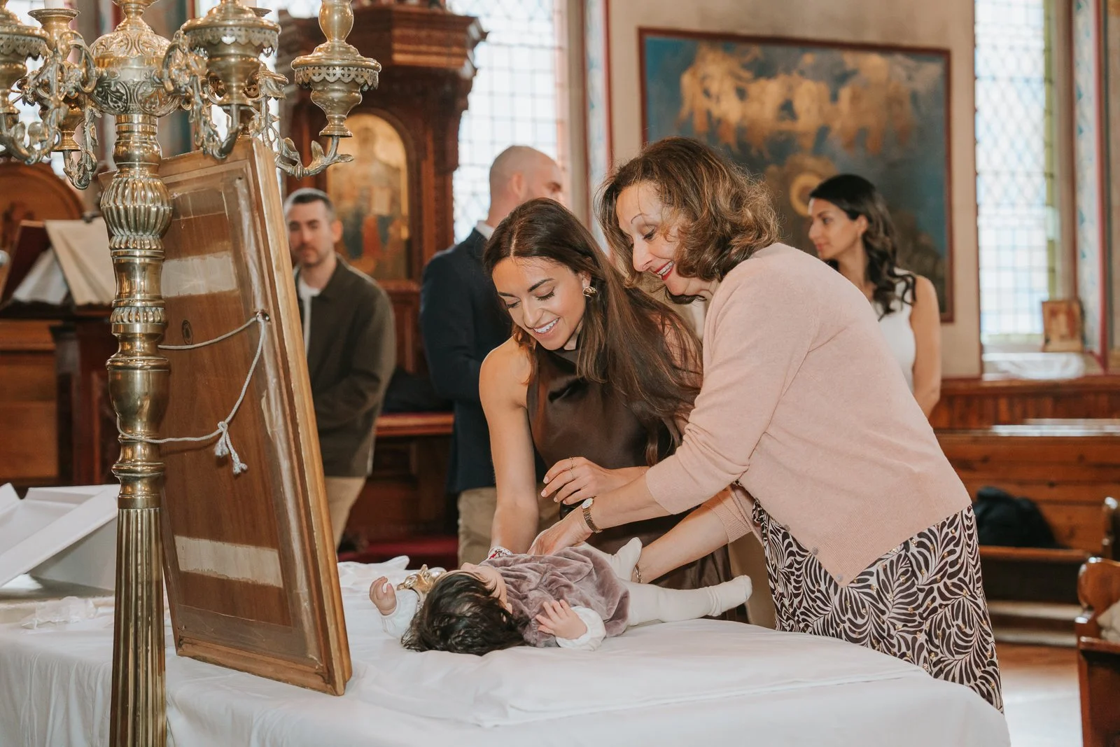  Baby being gently prepared for baptism during a christening at St Constantine &amp; St Helen Greek Orthodox Church in South London. 