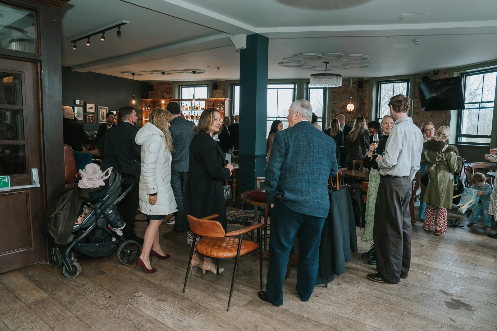 Guests mingling during a christening reception at Westow House pub in Crystal Palace, South London. 
