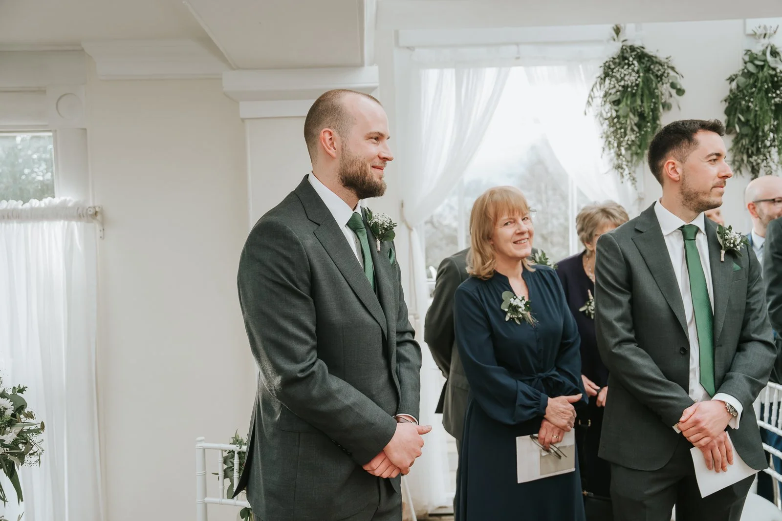  Groom waiting at the front of the Belvedere Suite during a Pembroke Lodge wedding ceremony, elegant Richmond Park venue with soft natural window light. 