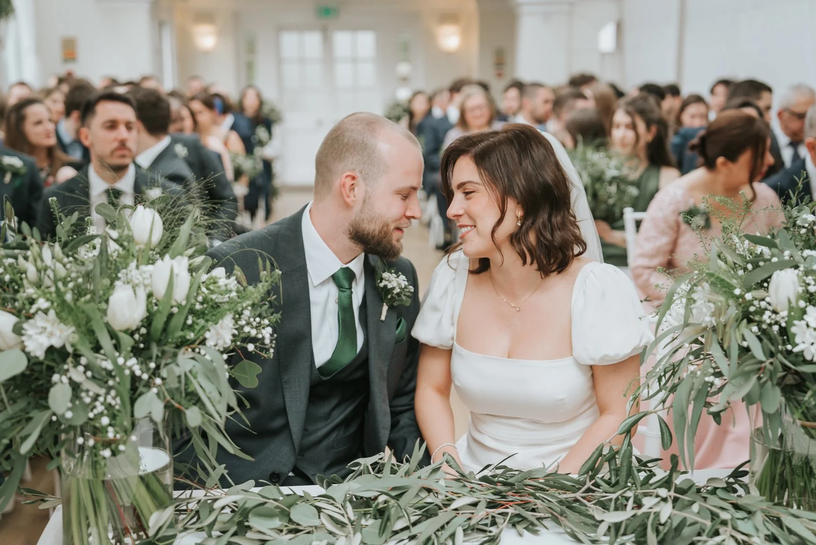  Bride and groom sharing a quiet moment after signing the register in the Belvedere Suite at Pembroke Lodge, Richmond Park wedding venue. 