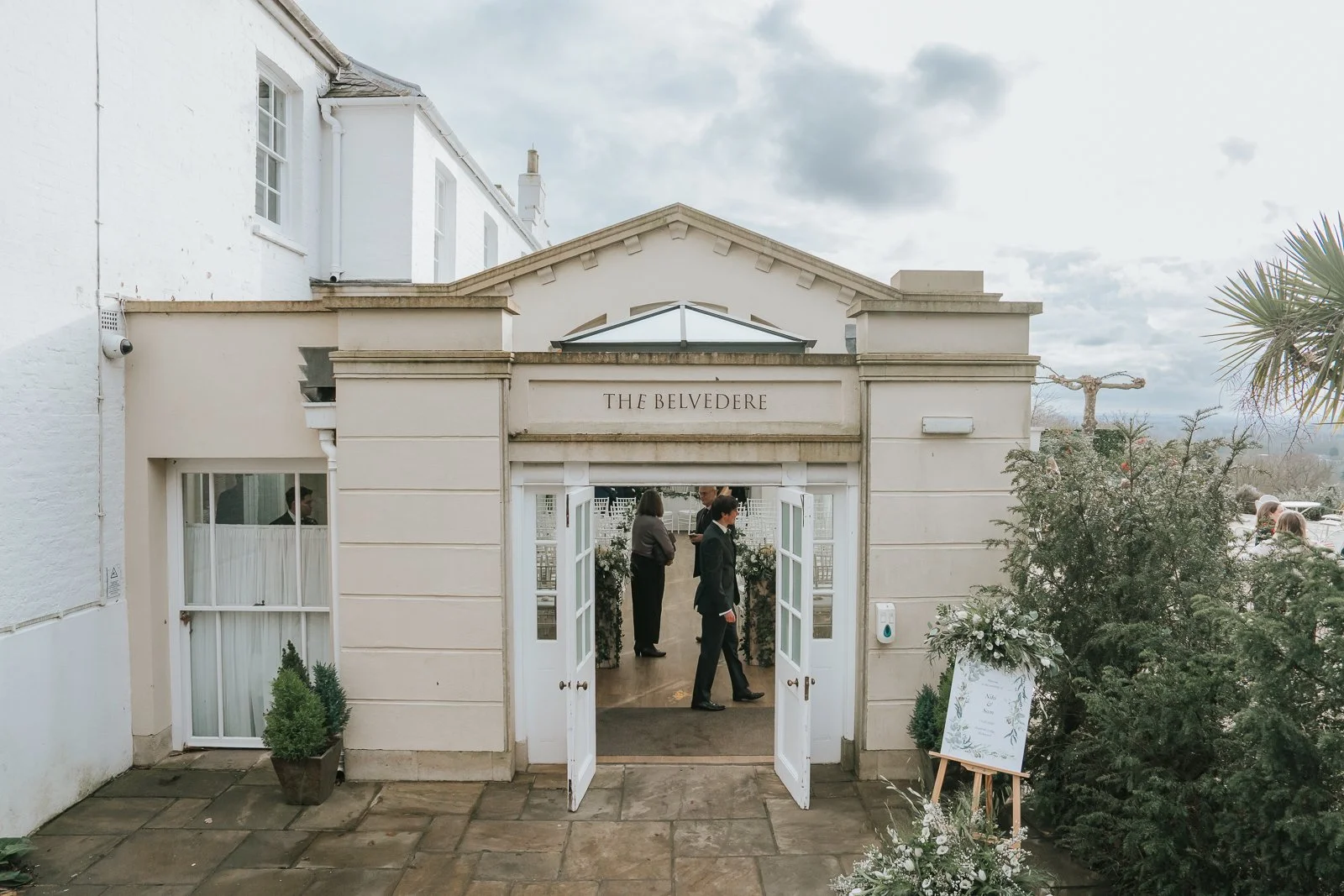  Entrance to the Belvedere Suite at Pembroke Lodge in Richmond Park, elegant London wedding ceremony venue with open doors ready for guests. 