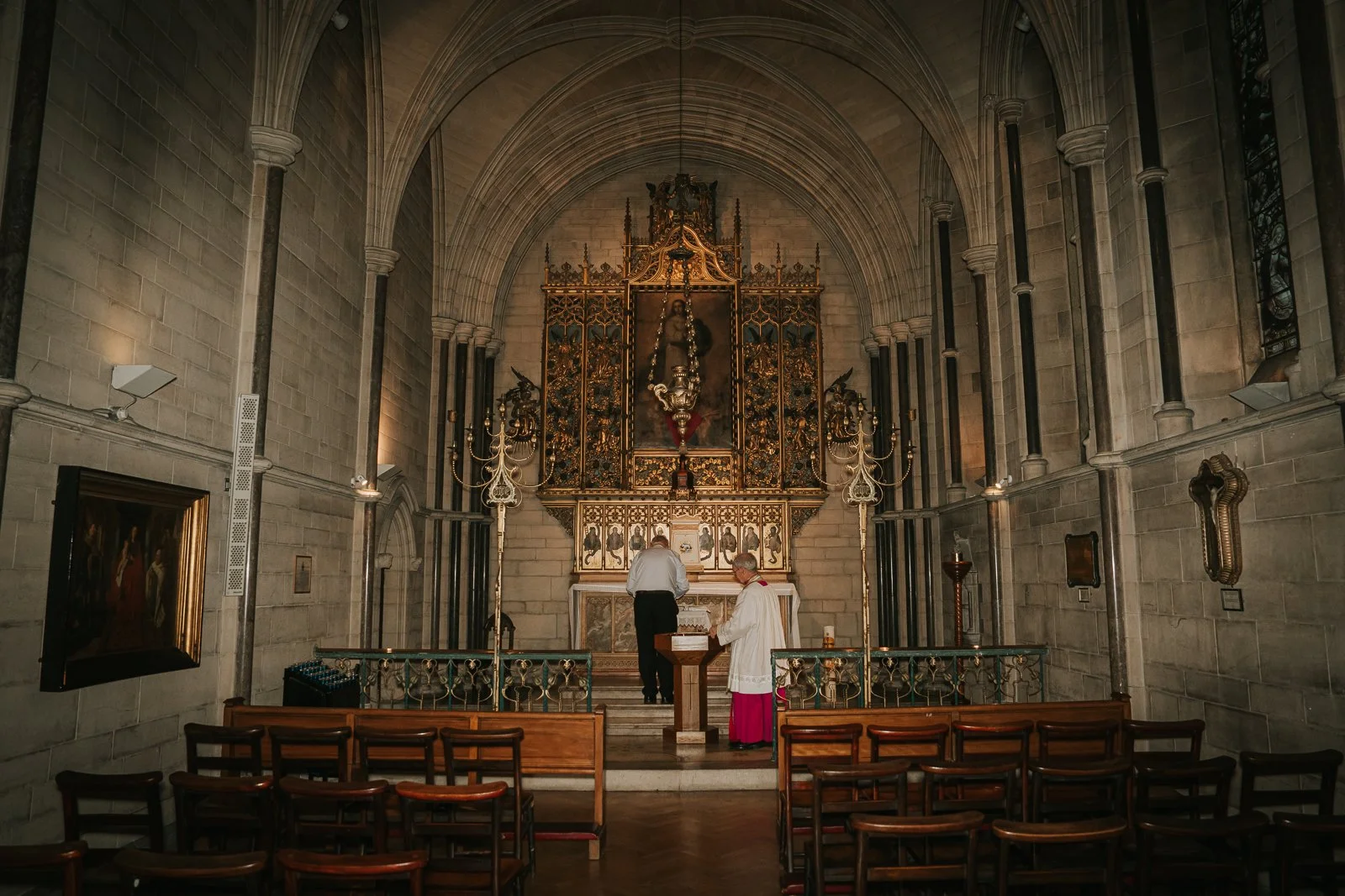  Priest preparing the altar inside St James’ Catholic Church Spanish Place London before a baptism ceremony, intimate church moment. 