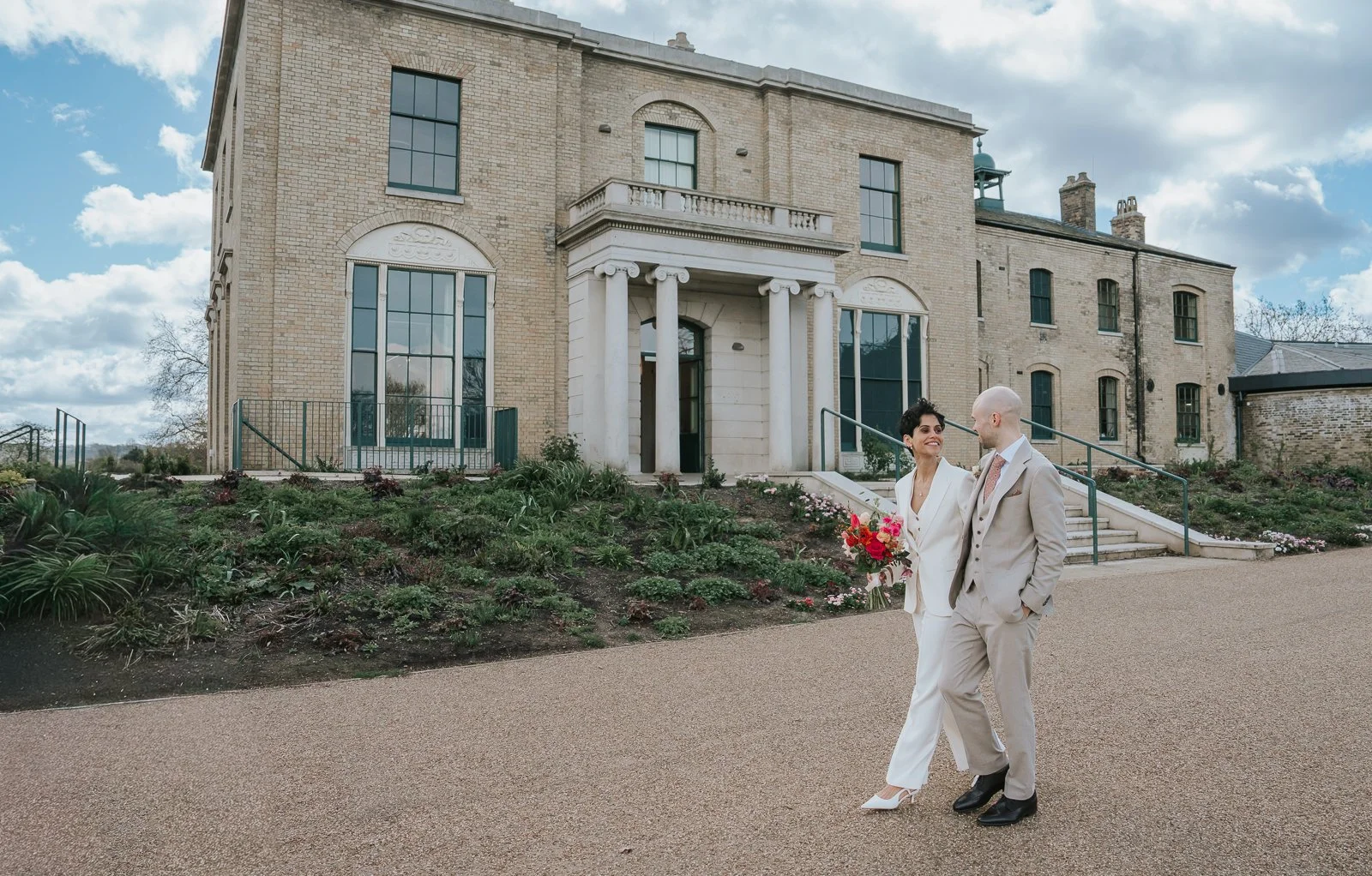  Bride and groom walking past Brockwell Hall gardens, natural documentary wedding photography at Brockwell Park South London venue. 