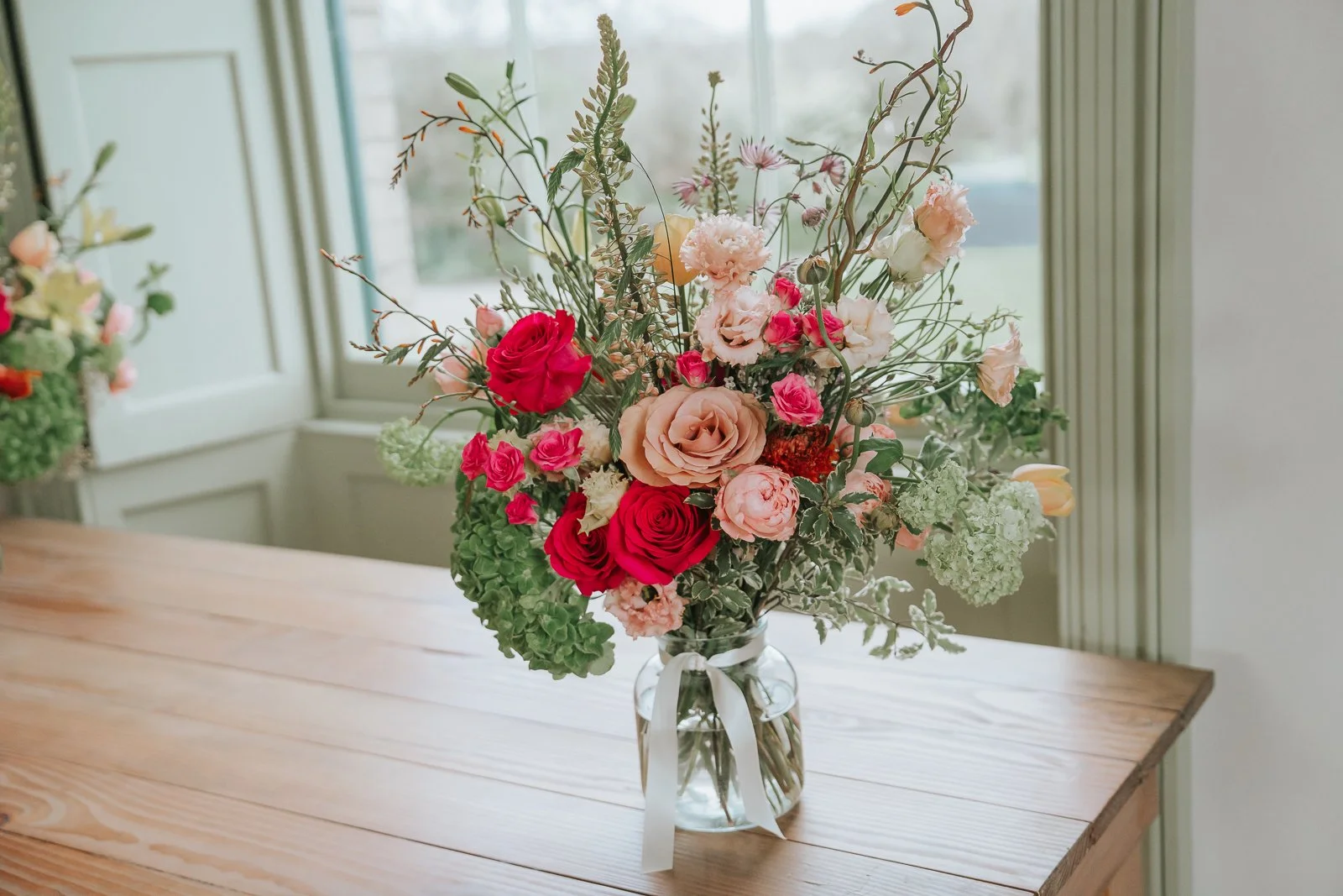  Wedding bouquet with roses and seasonal flowers on wooden table inside Brockwell Hall, elegant wedding details at Brockwell Park venue. 