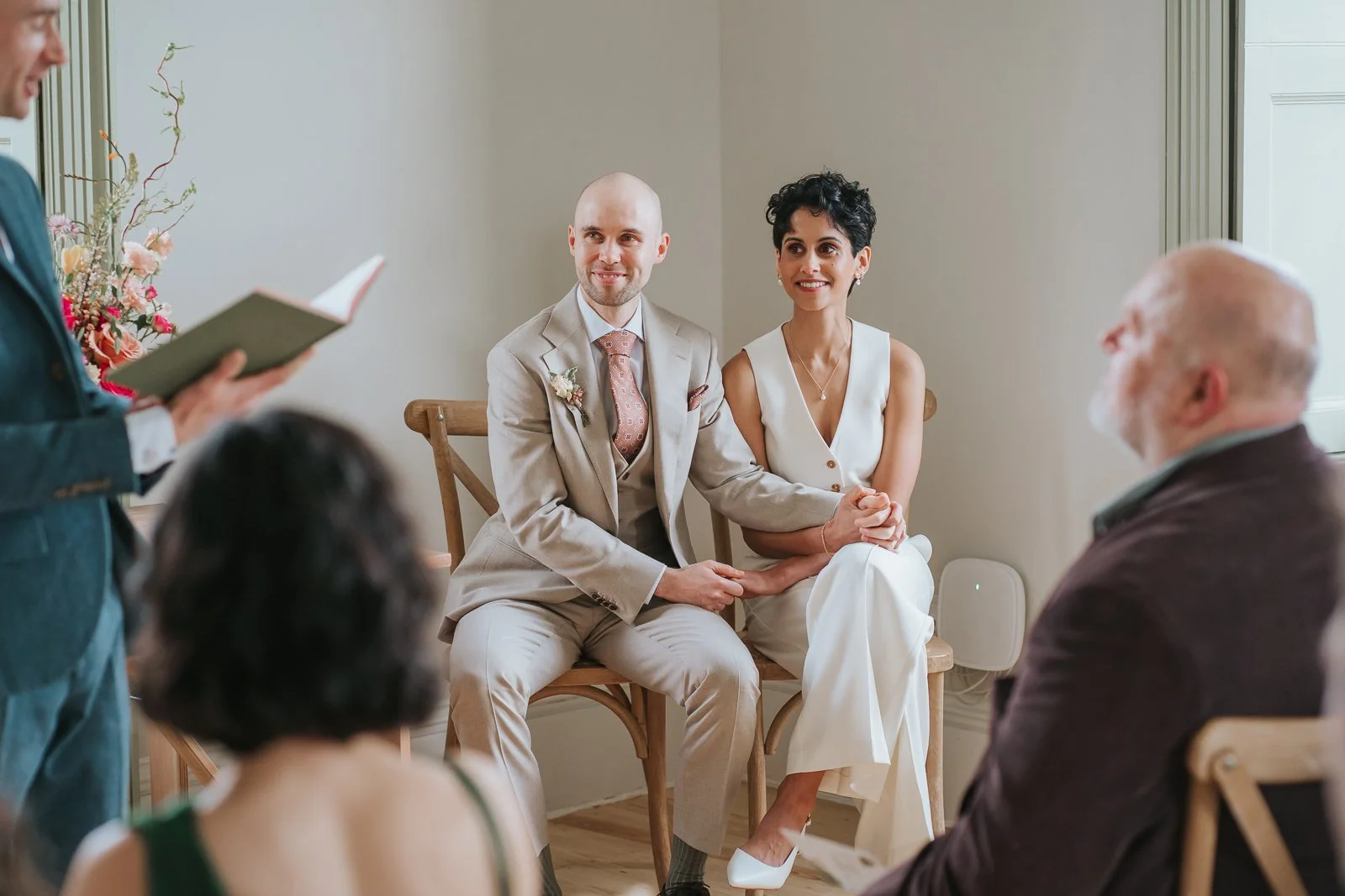  Bride and groom seated together during ceremony at Brockwell Hall. 