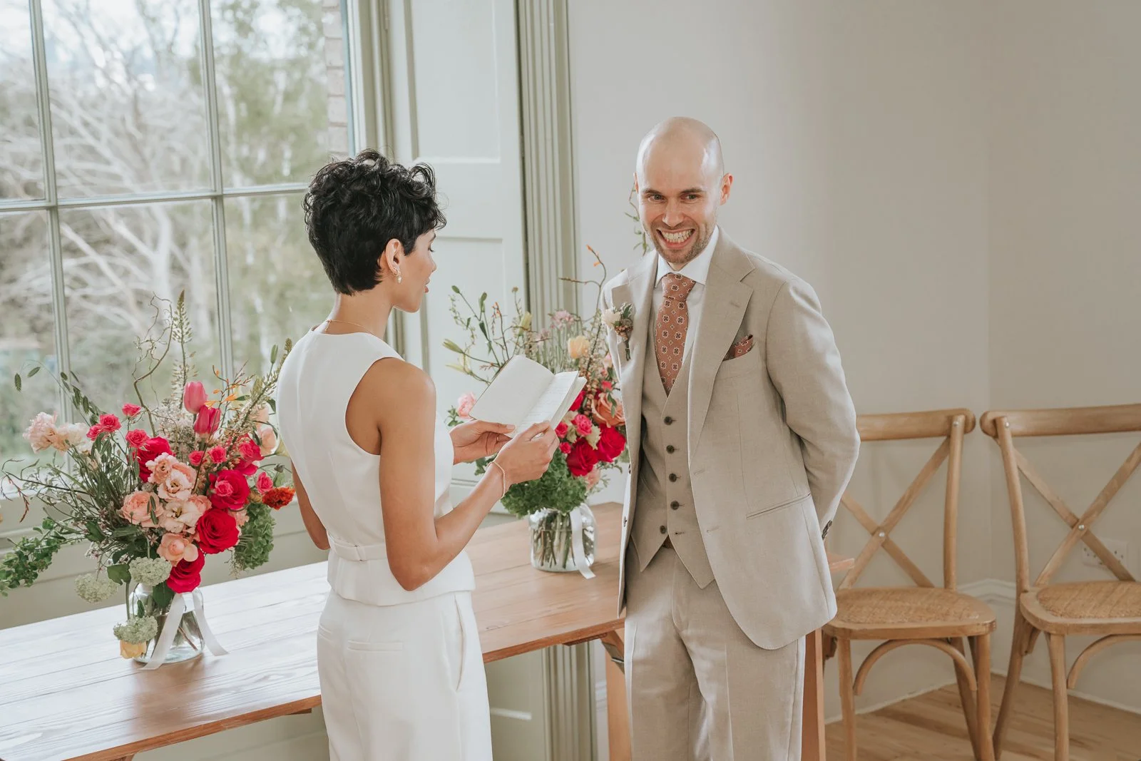  Groom smiling as bride reads vows during Brockwell Hall wedding ceremony, intimate South London civil wedding moment. 