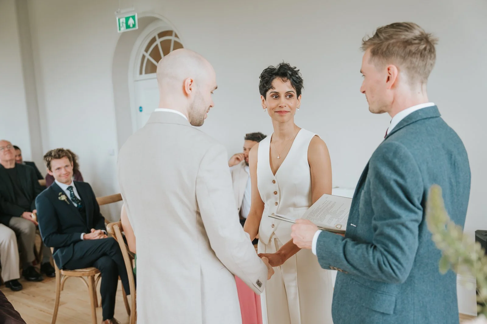  Bride and groom standing together during ceremony at Brockwell Hall, elegant civil wedding setting in Brockwell Park. 