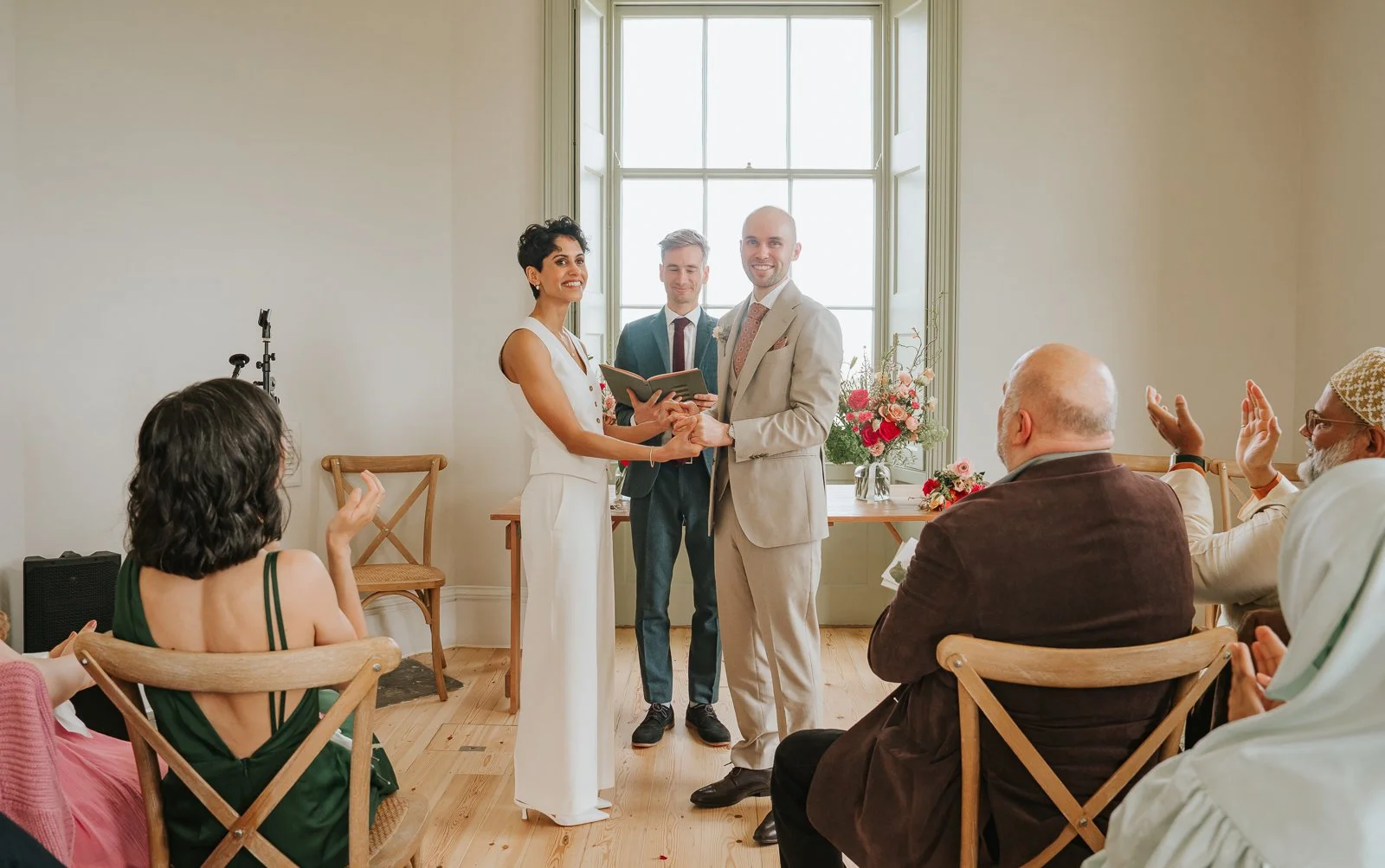  Newly married couple holding hands at Brockwell Hall after ceremony, intimate South London civil wedding celebration. 
