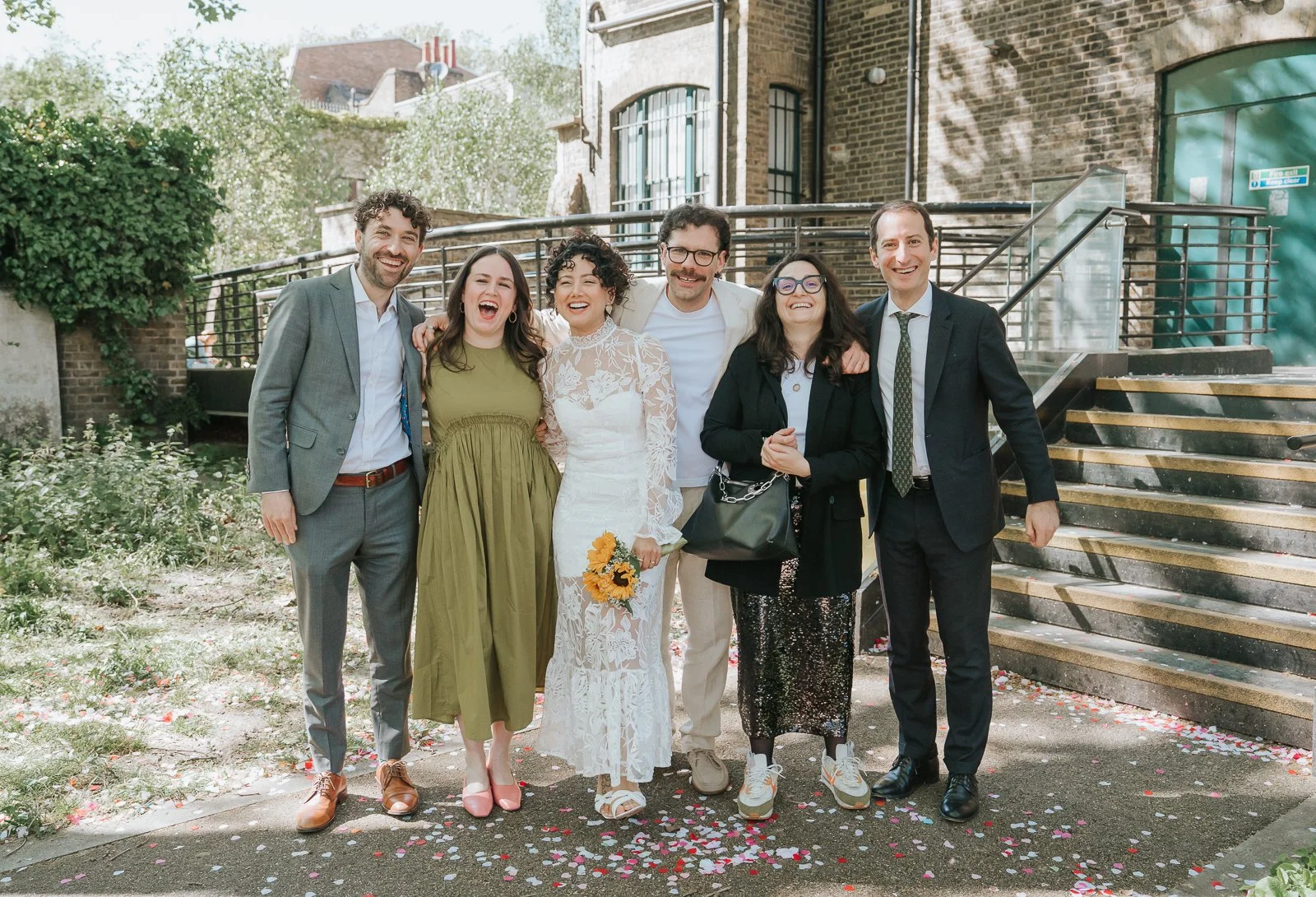  Wedding group photo outside Tower Hamlets Register Office with steps and confetti after ceremony. 