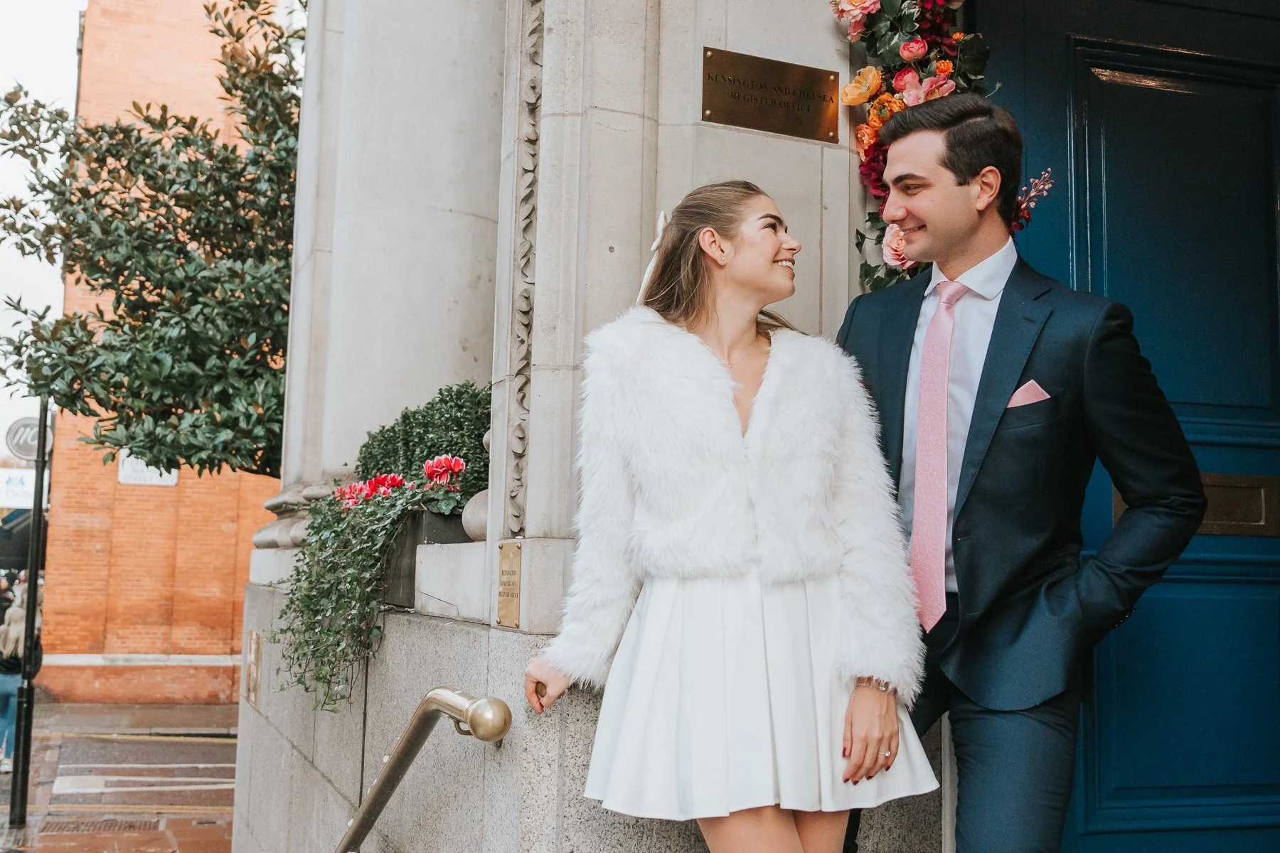  Bride and Groom pose for a photograph on the steps outside Chelsea Old Town Hall. 