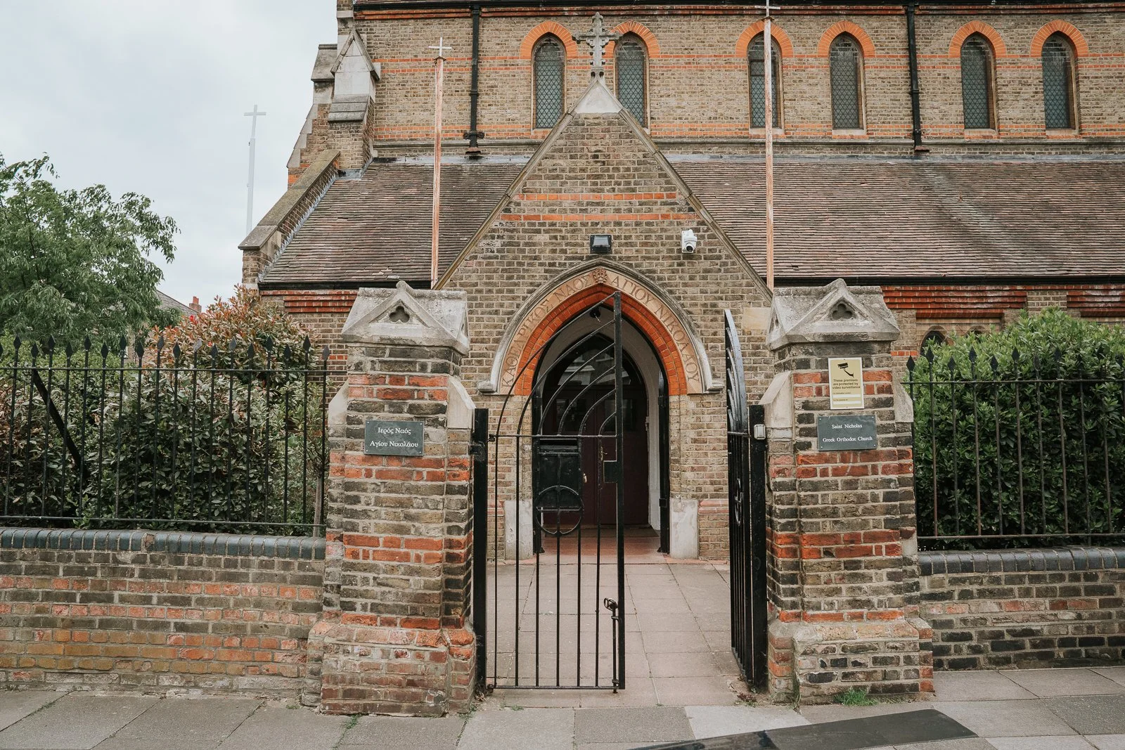  Exterior of St Nicholas Greek Orthodox Church in Shepherd’s Bush, West London, showing the historic brick church entrance and front gates. 