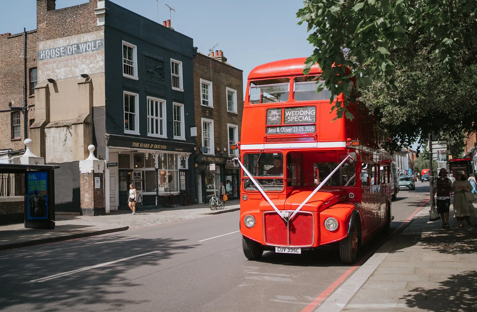  View of a classic red London bus driving towards Islington Town Hall. 