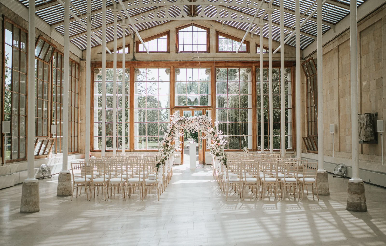  The Nash Conservatory wedding ceremony setup at Kew Gardens with floral arch and natural light. 