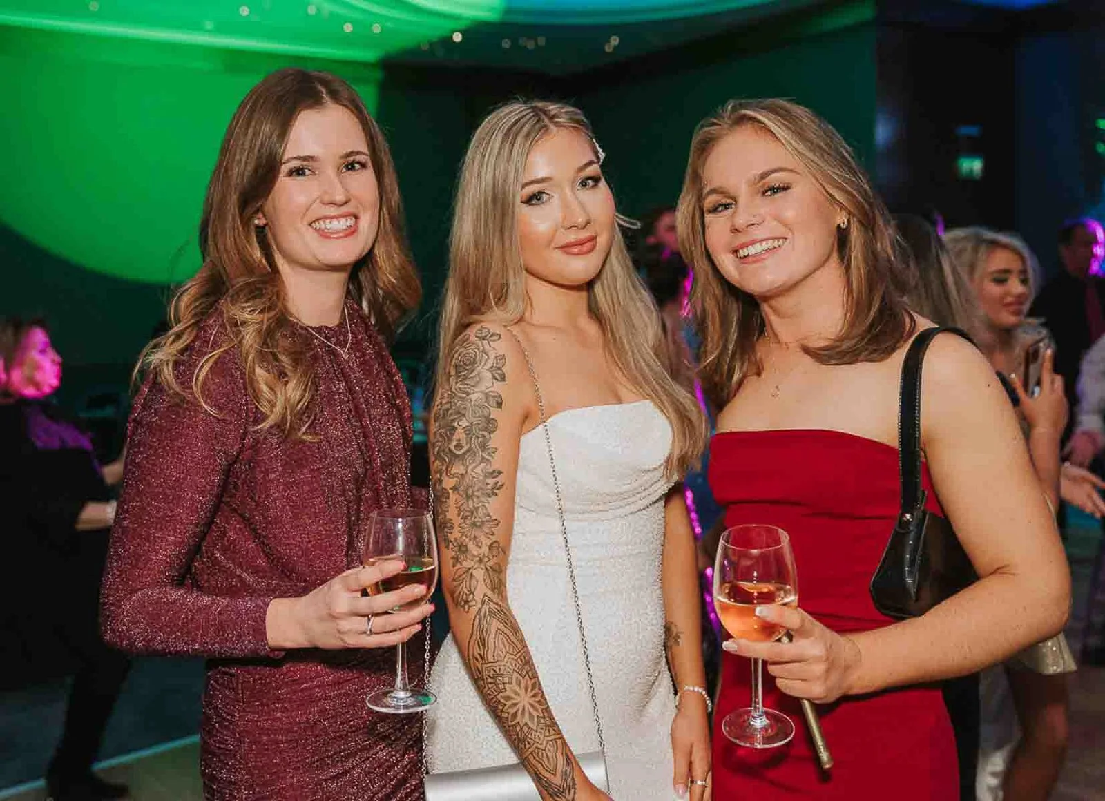   Guests dressed for a special occasion posing for a birthday party photograph in a trendy Balham bar venue.  