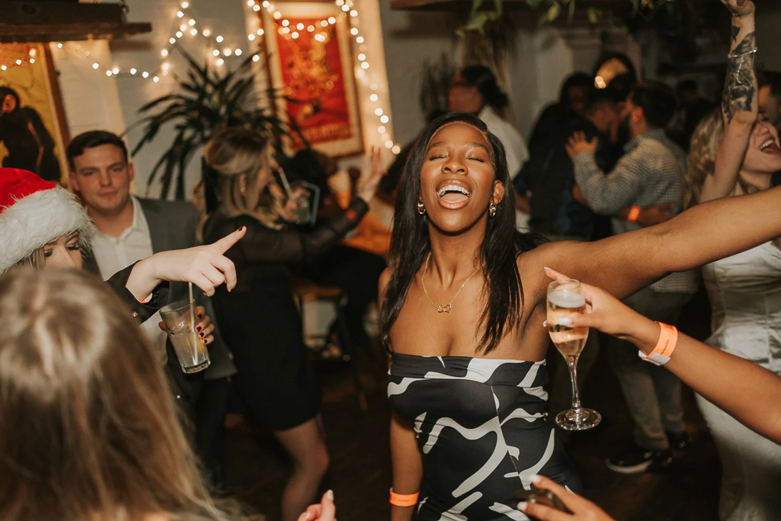  Birthday party guest dancing and singing along with friends at a lively South London celebration, photographed candidly. 