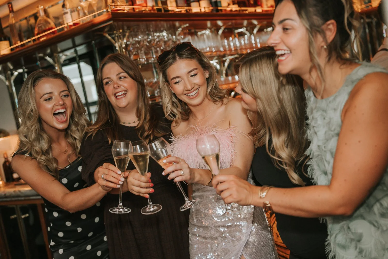  Friends raising champagne glasses during a stylish 30th birthday celebration, captured by a London event photographer. 