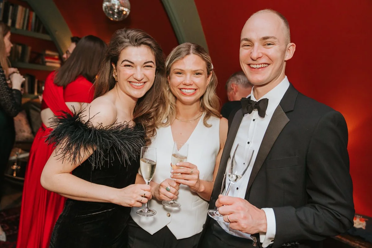  Three friends enjoying drinks and celebrating together at a 30th birthday party in London, captured with natural event photography. 