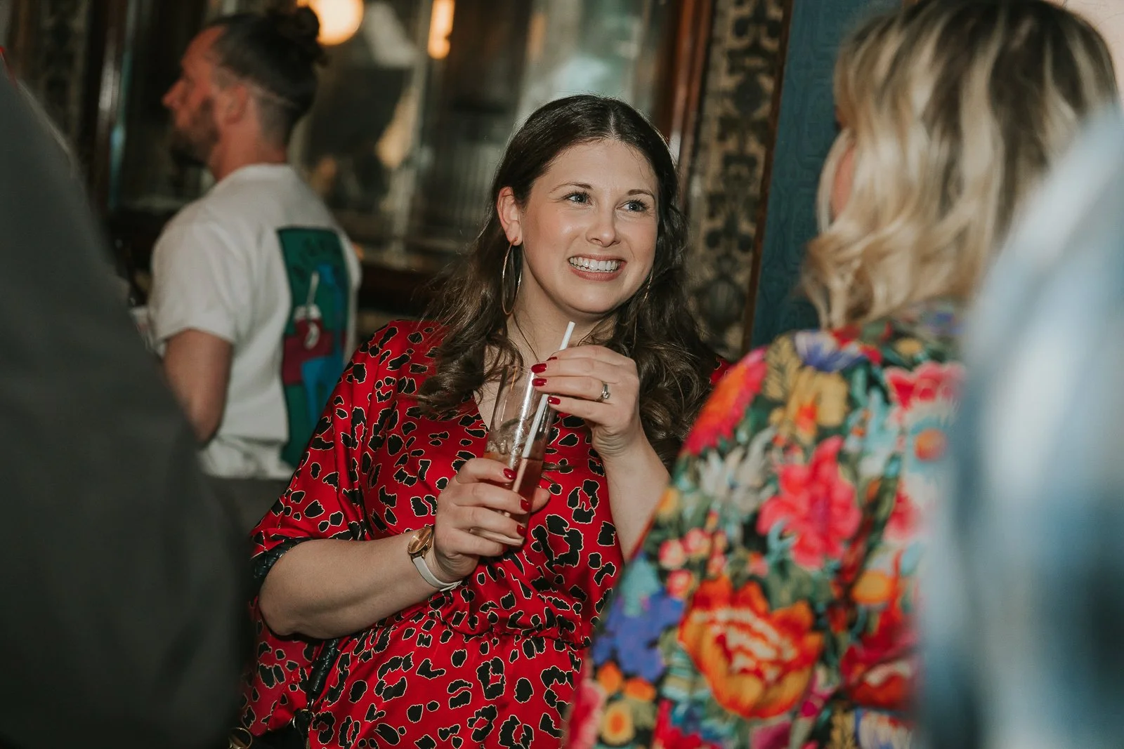  Guest chatting with friends over cocktails at a stylish 40th birthday party in South London, captured with natural documentary event photography. 