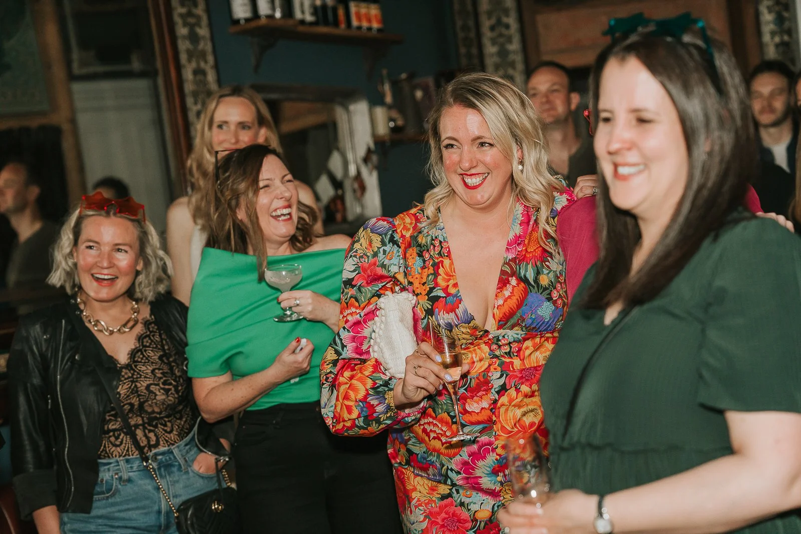  Guests laughing and enjoying live music during a memorable 40th birthday party in a stylish London bar. 