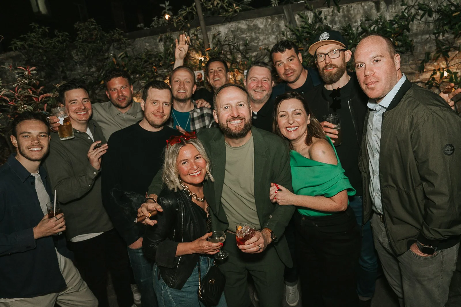  Large group of friends and family celebrating a 40th birthday party outdoors on a summer evening in London. 