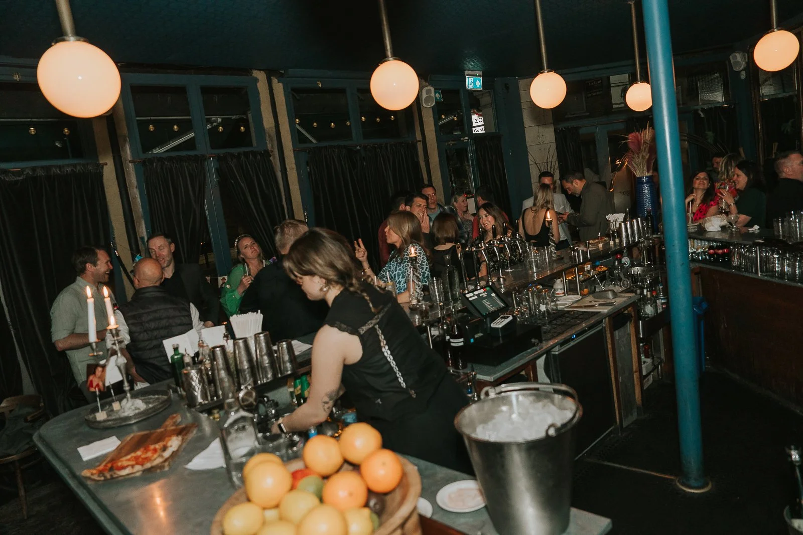  Stylish London bar venue hosting a 40th birthday party, with guests mingling and enjoying drinks in a relaxed setting. 
