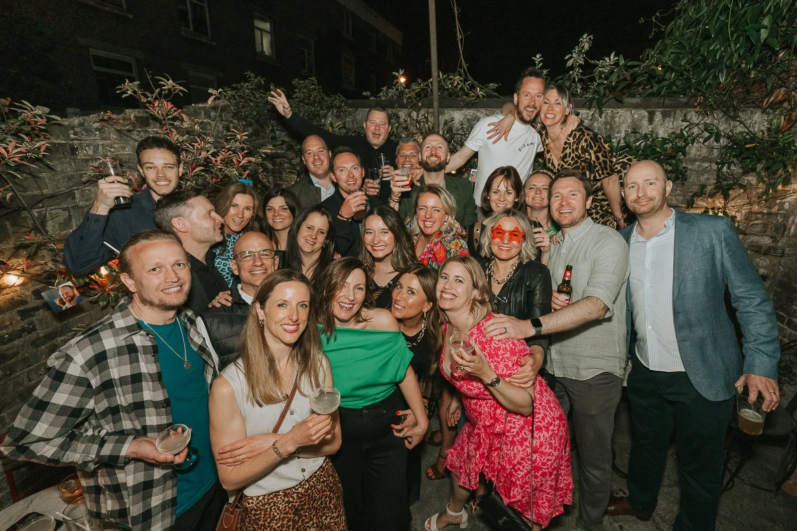  Large group photo of friends celebrating a 40th birthday party outdoors at a South London venue, captured with natural and relaxed documentary event photography. 