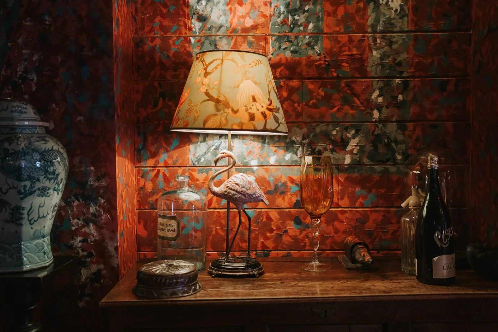  Vintage flamingo table lamp and eclectic décor displayed against richly patterned red wallpaper at The Zetter Townhouse Clerkenwell wedding reception venue. 