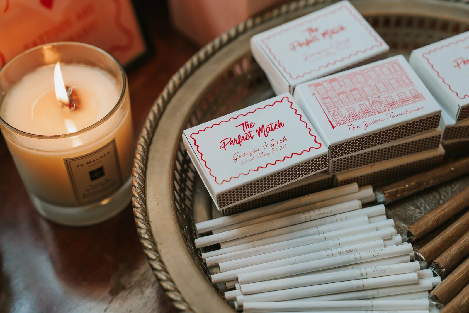  Personalised wedding matchboxes and candle favours displayed on a silver tray at The Zetter Townhouse Clerkenwell reception. 