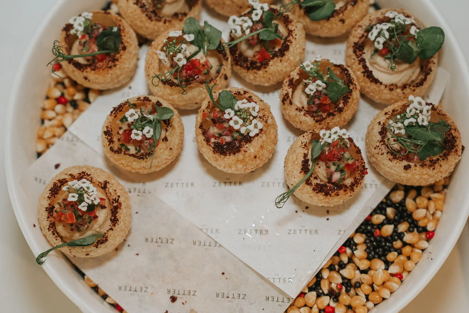  Elegant canapé selection served at a wedding reception at The Zetter Townhouse Clerkenwell, featuring beautifully presented bite-sized appetisers garnished with microgreens and edible flowers. 