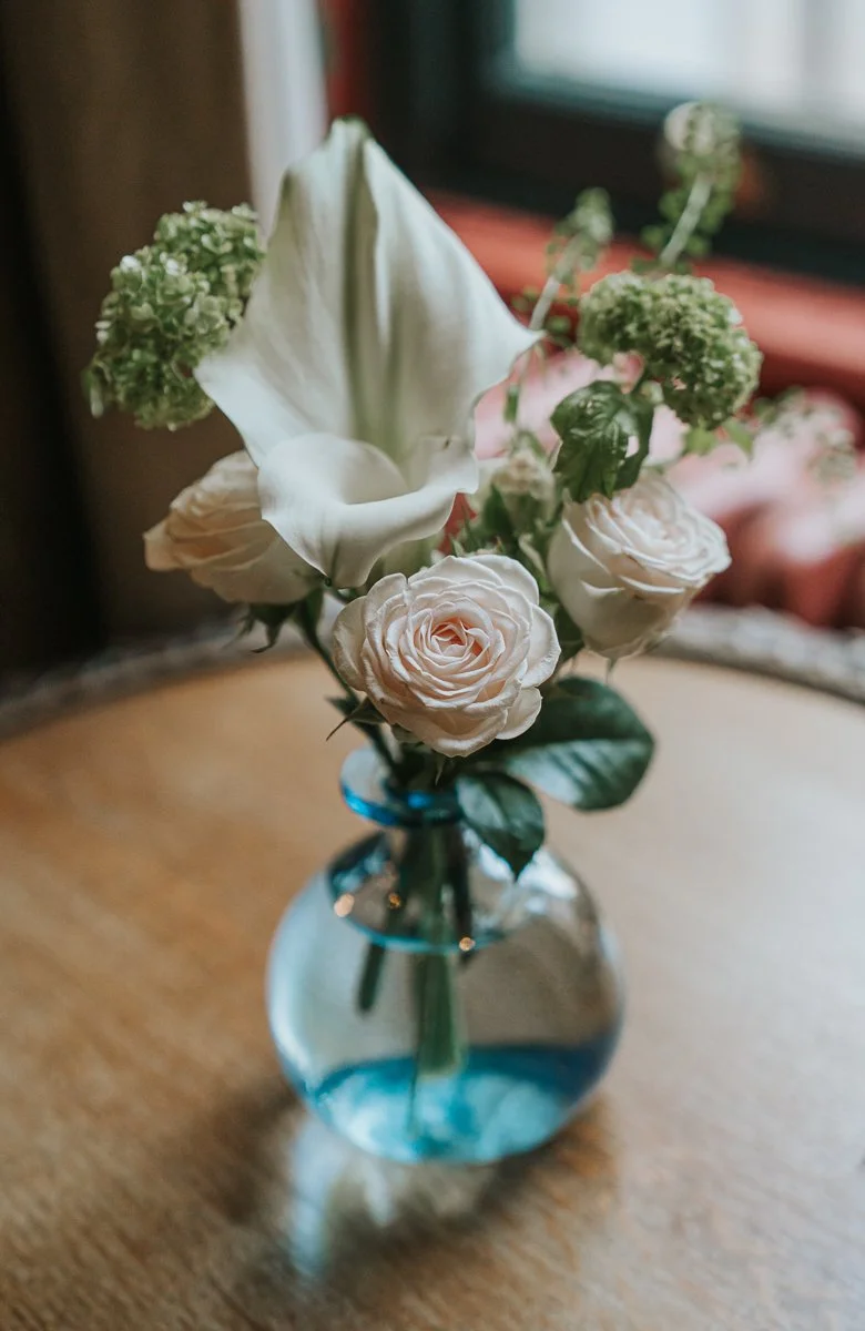  Delicate white rose and calla lily arrangement displayed in a glass vase as elegant wedding décor at The Zetter Townhouse Clerkenwell. 
