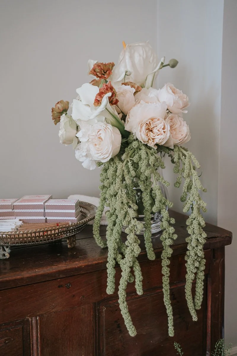  Elegant bridal bouquet featuring ivory roses, calla lilies and trailing greenery displayed inside The Zetter Townhouse Clerkenwell. 
