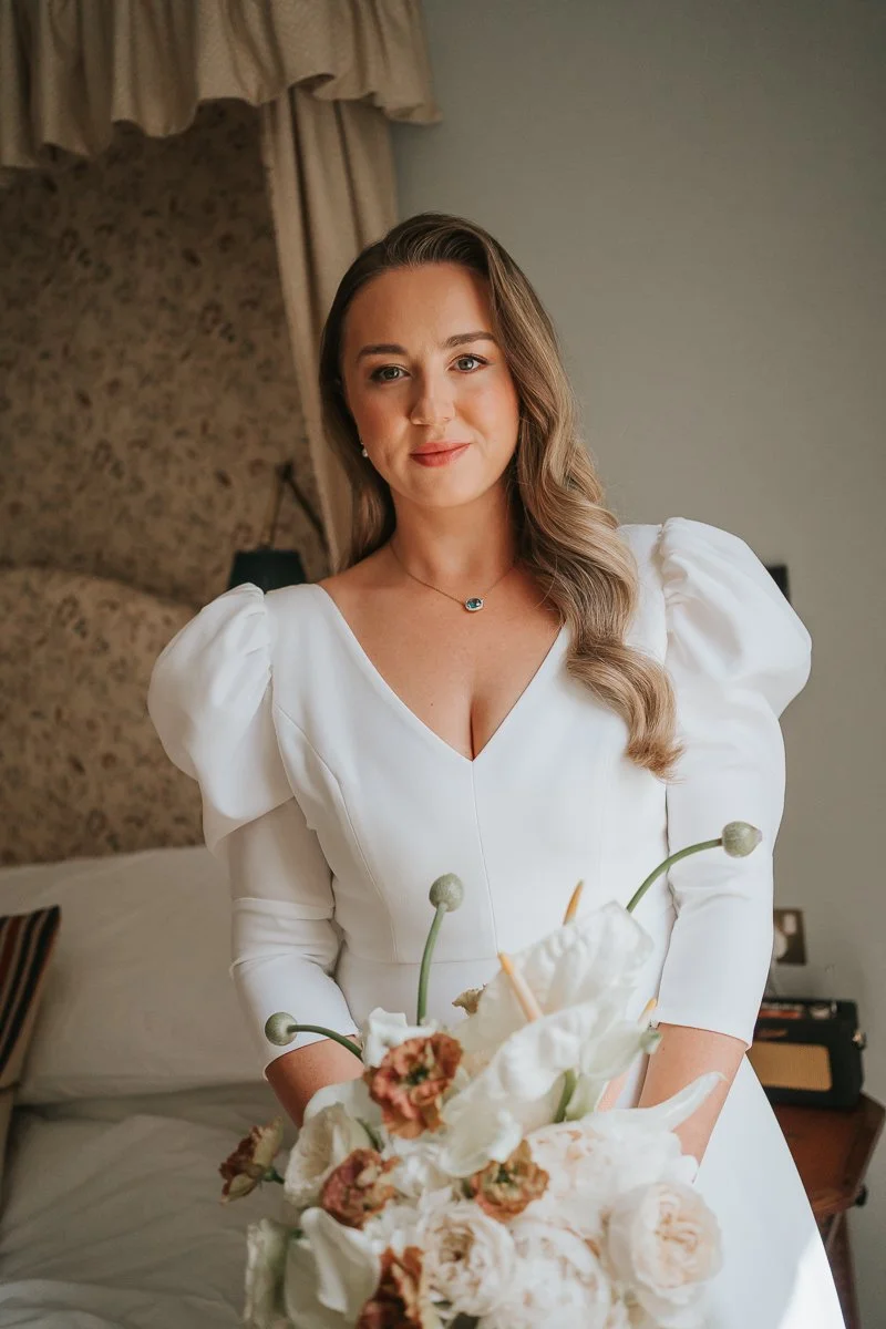  Bride portrait in a stylish bedroom at The Zetter Townhouse Clerkenwell, holding a romantic bouquet before her London wedding ceremony. 