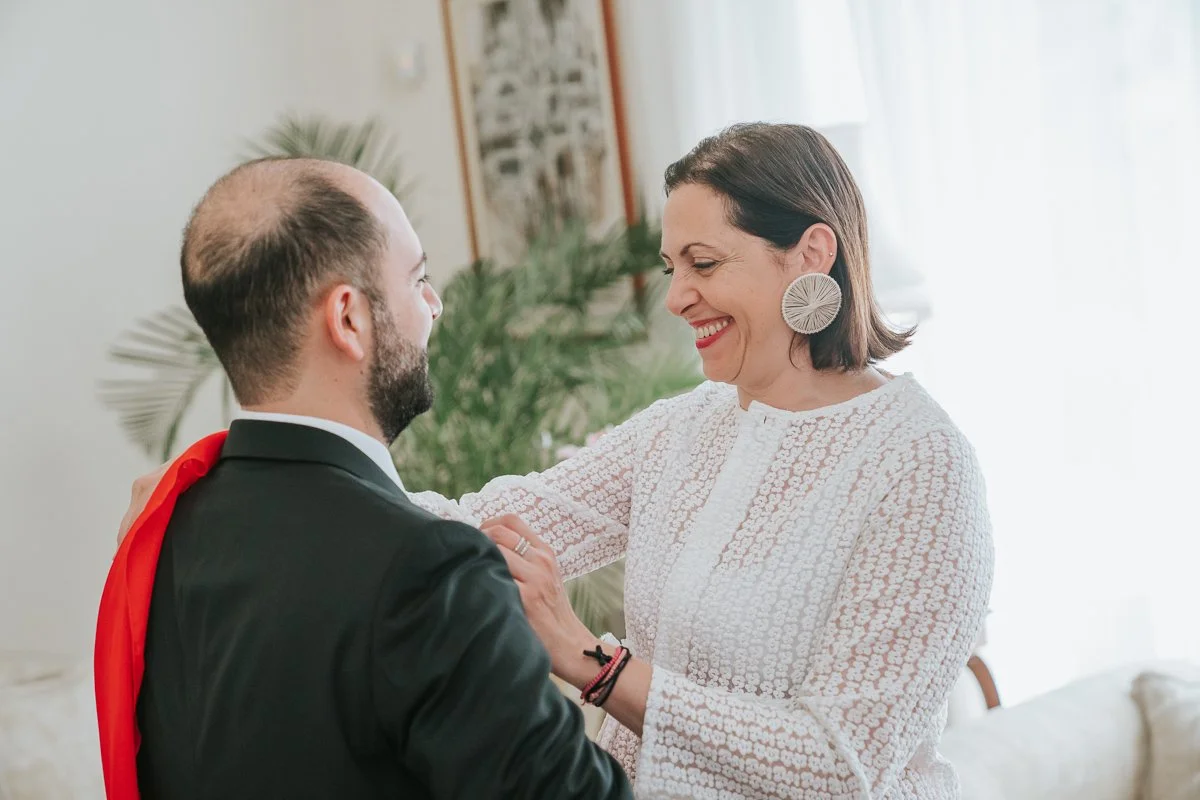  Mother blessing her son on his wedding day during a heartfelt Greek Orthodox stolisma before the ceremony begins. 
