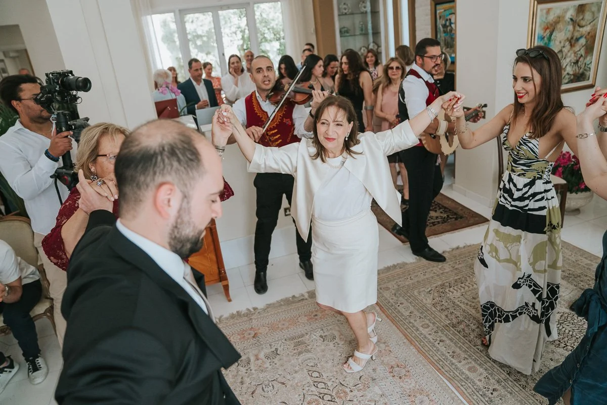  Family and friends dancing to traditional Greek music during a joyful stolisma celebration before a Greek Orthodox wedding in London. 