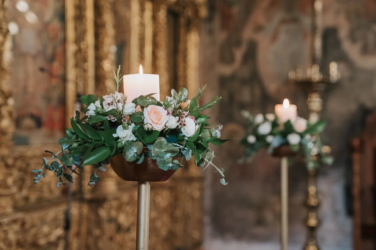  Floral candle arrangements inside a Greek Orthodox church, creating a beautiful and traditional setting for a Greek wedding ceremony. 