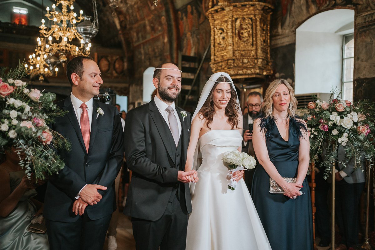  The crowning ceremony during a Greek Orthodox wedding as the bride and groom wear their stefana crowns inside a historic church. 