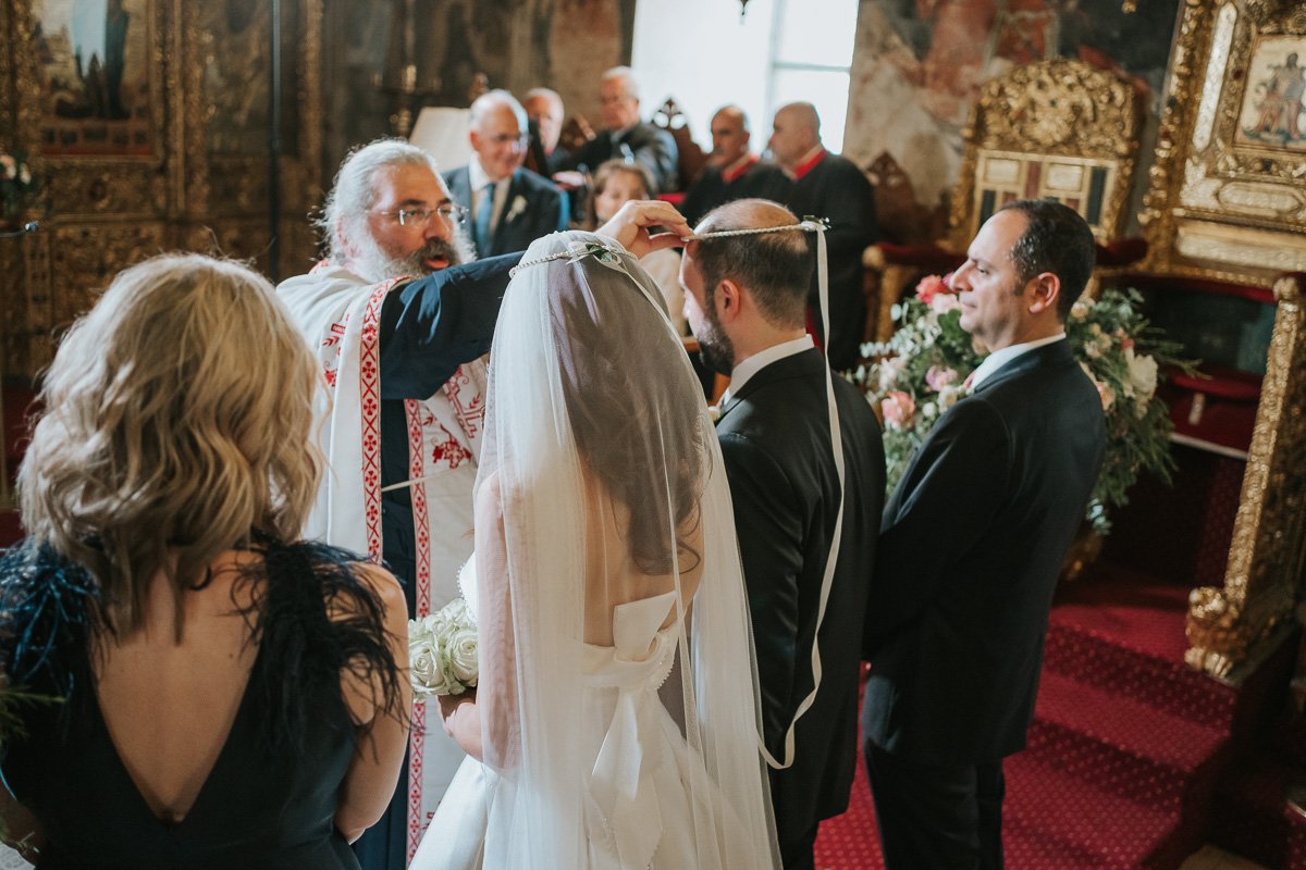  The crowning ceremony during a Greek Orthodox wedding as the bride and groom wear their stefana crowns inside a historic church. 