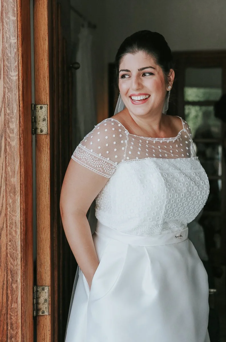  Bride smiling by a door during her Greek Orthodox wedding preparations, moments before leaving for the church ceremony. 