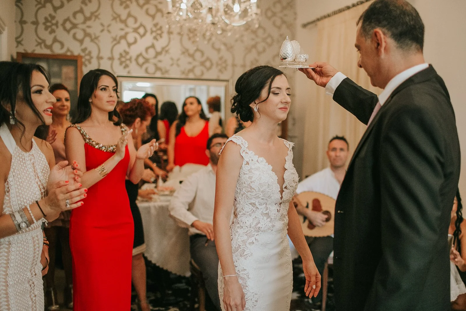  Bride laughing as her father performs a traditional blessing during the Greek Orthodox wedding preparations. 