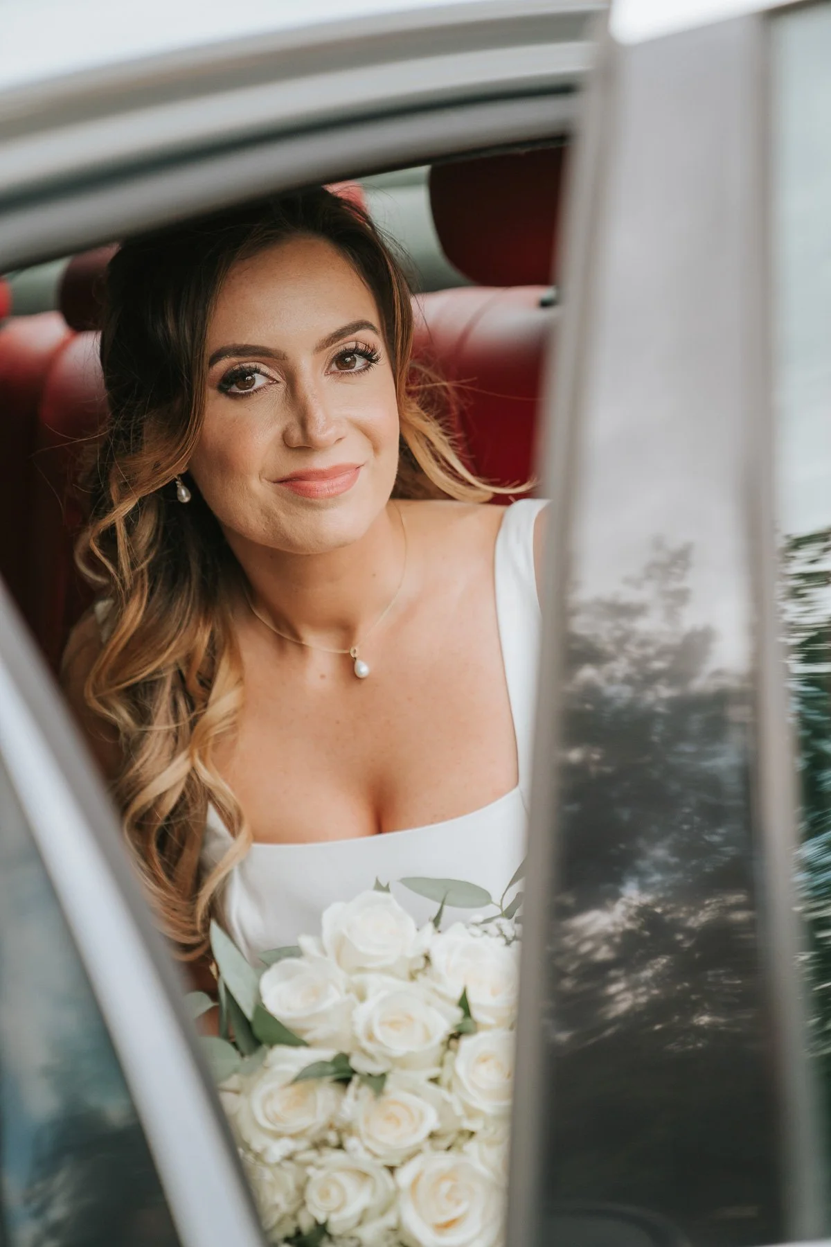  Bride sitting in the wedding car holding a bouquet of white roses as she arrives for her Greek Orthodox wedding ceremony in London. 